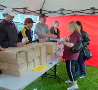 Coaches pickup team photos, trophies & cards on  HotDog Day at Wilson Park